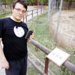 Bojan, wearing a Wikipedia T-shirt, checking a QR code on an information plaque.
