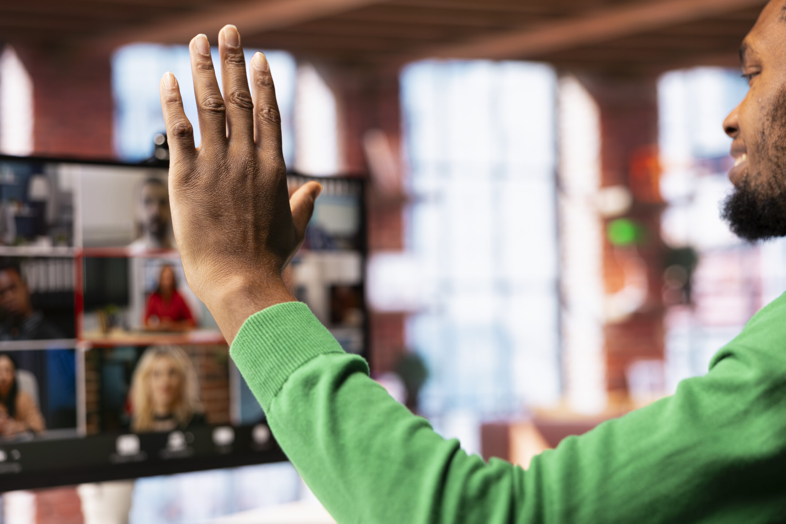 Team leader at home saluting teleworkers during remote videoconference meeting